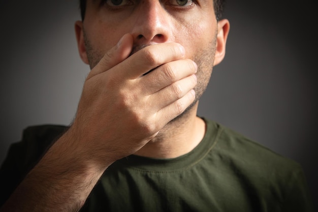 Caucasian man covering his mouth with hand Secret