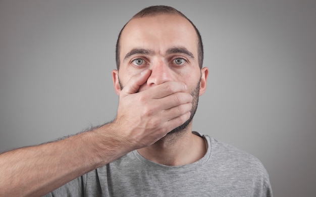 Caucasian man covering his mouth with hand Secret