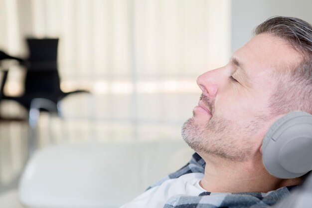 Caucasian man enjoying music on the sofa