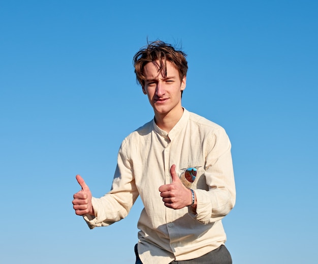 A Caucasian man from Spain making a thumbs up sign with both hands on clear sky