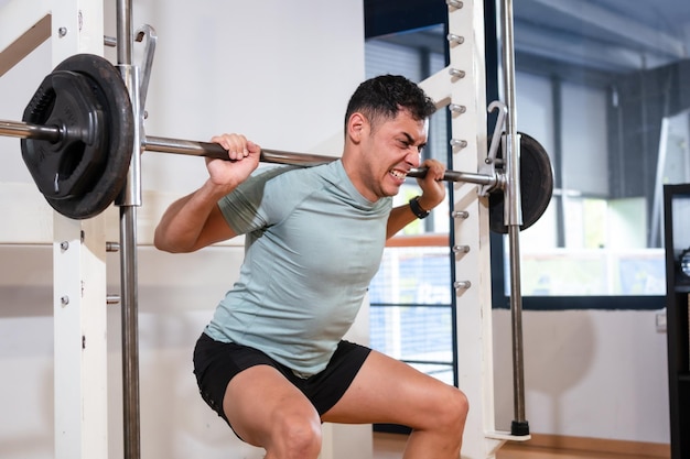 A caucasian man in the gym lifting weights with a lot of effort healthy and healthy life doing sports