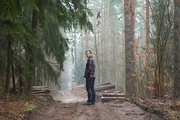 Caucasian man has a walk in foggy forest