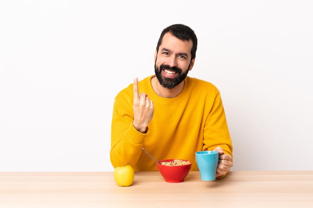 今後のジェスチャーを行うテーブルで朝食を持っている白人の男