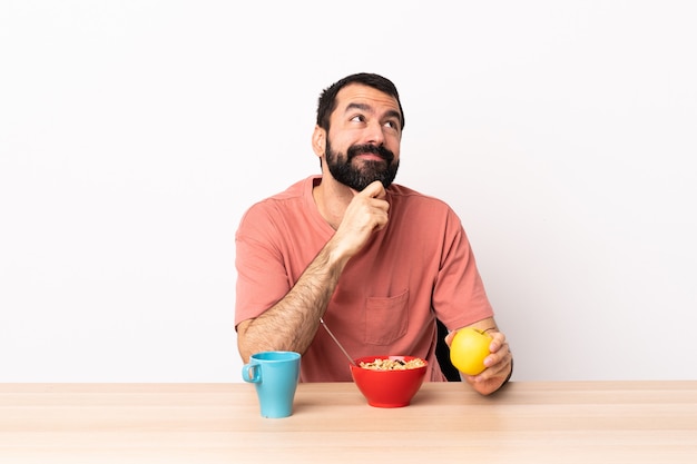 Caucasian man having breakfast in a table and looking up