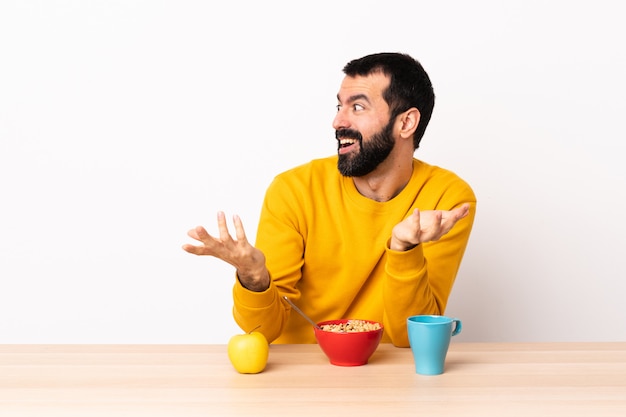 Caucasian man having breakfast in a table with surprise expression while looking side