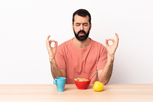 Caucasian man having breakfast in a table in zen pose