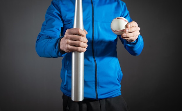 Caucasian man holding baseball bat and ball