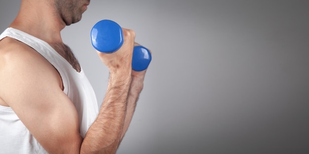 Caucasian man holding blue dumbbell