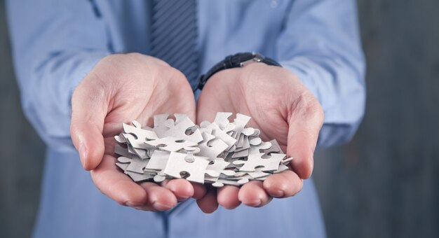 Caucasian man holding puzzle pieces.