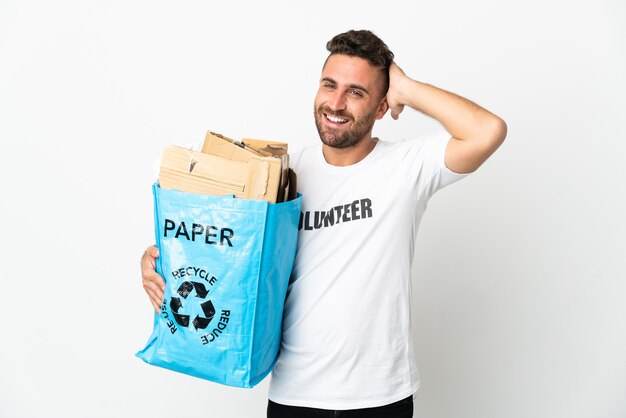 Caucasian man holding a recycling bag full of paper to recycle isolated on white wall smiling a lot