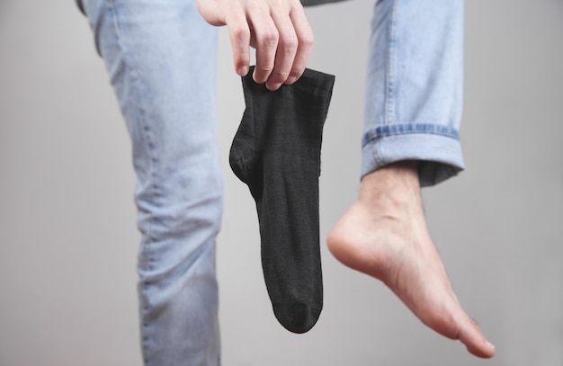 Caucasian man holding socks in home.