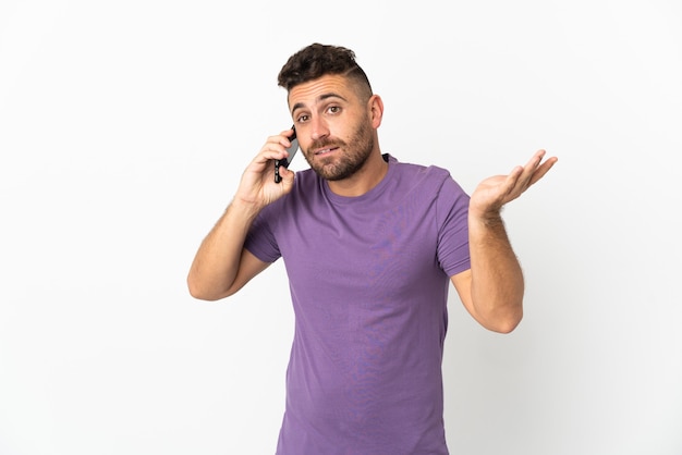 Uomo caucasico isolato su bianco mantenendo una conversazione con il telefono cellulare con qualcuno