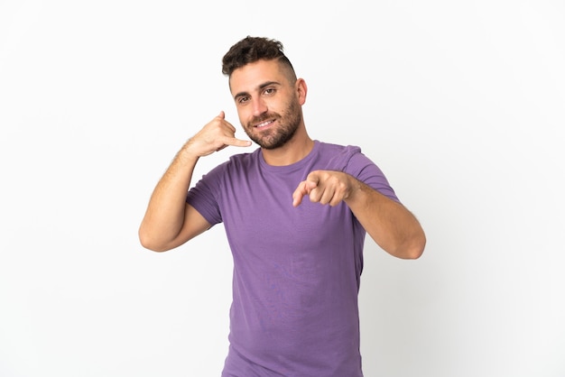 Caucasian man isolated on white making phone gesture and pointing front