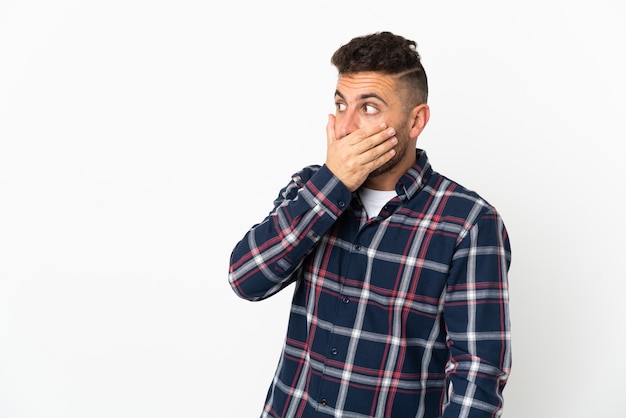 Caucasian man isolated on white wall doing surprise gesture while looking to the side