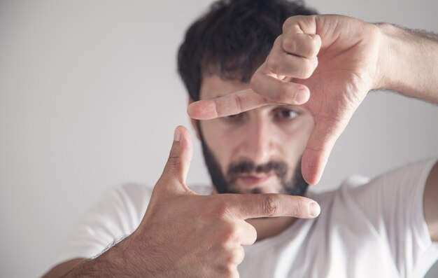 Caucasian man making frame with hands.