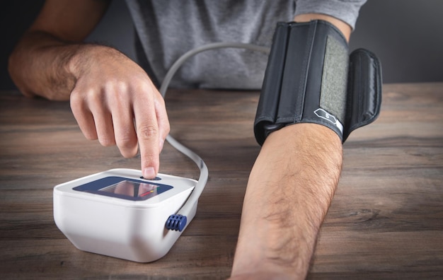 Caucasian man measuring his blood pressure at home