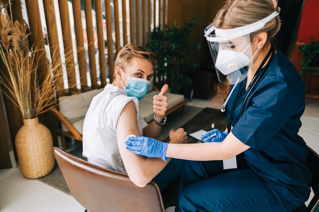 Caucasian man patient getting vaccinated against coronavirus receiving covid vaccine. Intramuscular injection during doctor's appointment in hospital. Covid-19 Vaccination.