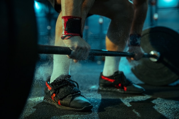 Caucasian man practicing in weightlifting in gym. Close up of male sportive model preparing for training, looks strong. Body building, healthy lifestyle, movement, activity, action concept.