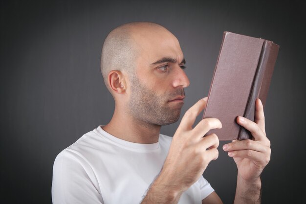 Caucasian man reading book in office.