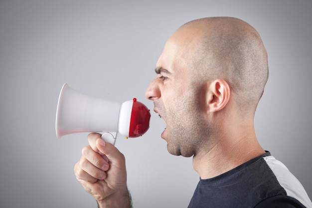 Caucasian man screaming with megaphone.