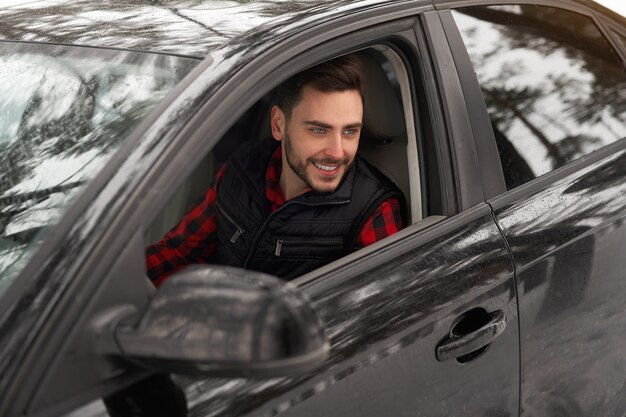 caucasian man sits at the wheel of his car