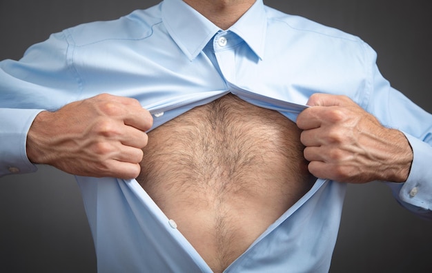 Caucasian man tearing a shirt showing hairy bare body