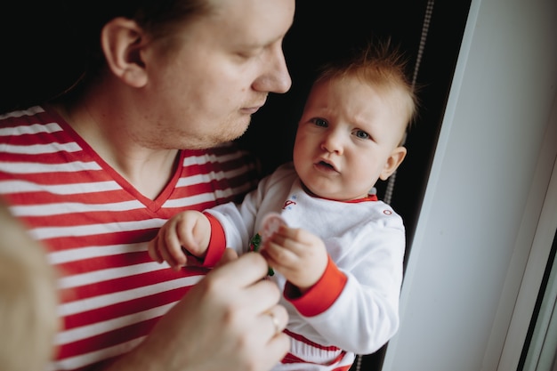 caucasian man with baby daugher standing by window