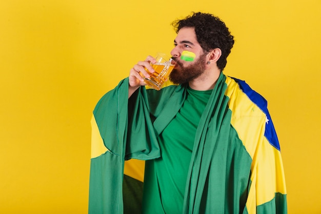 Caucasian man with beard brazilian soccer fan from brazil drinking beer from mug good beer concept