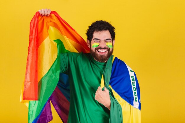 Uomo caucasico con barba tifoso brasiliano di calcio brasiliano che indossa flagxaconcetto di diversità lgbt