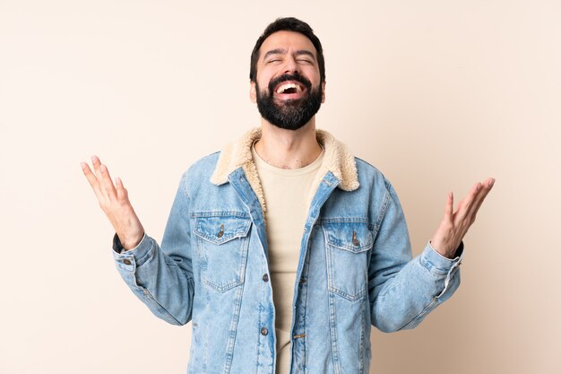 Caucasian man with beard over wall smiling a lot