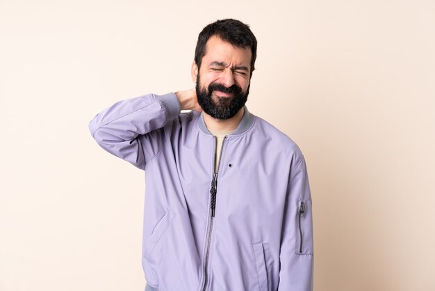 Caucasian man with beard wearing a jacket over isolated background with neckache