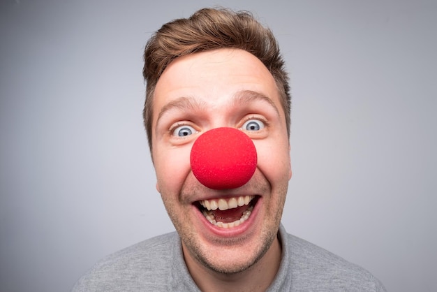 Фото Белый мужчина с сумасшедшим взглядом и клоунским носом