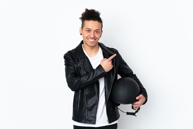 Caucasian man with a motorcycle helmet over isolated white background pointing finger to the side