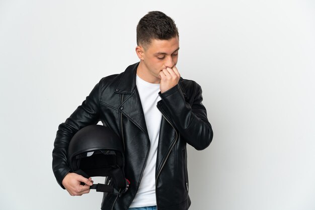 Uomo caucasico con un casco da motociclista isolato su bianco che ha dubbi