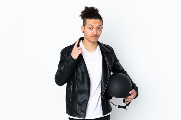 Caucasian man with a motorcycle helmet over isolated white wall pointing with the index finger a great idea