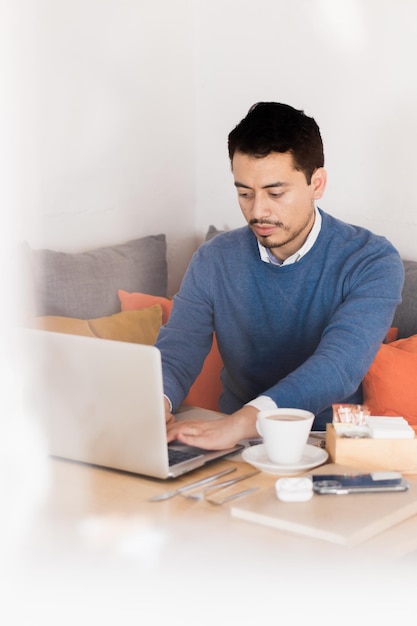 Caucasian man with serious expression working with a computer in an office.