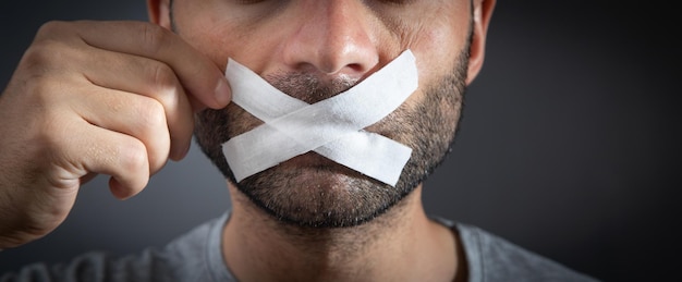 Caucasian man with tape on mouth Censorship