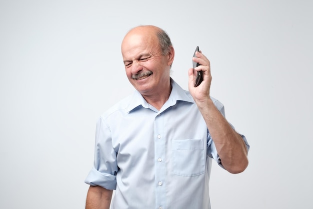 Caucasian mature man is irritated with phone conversation