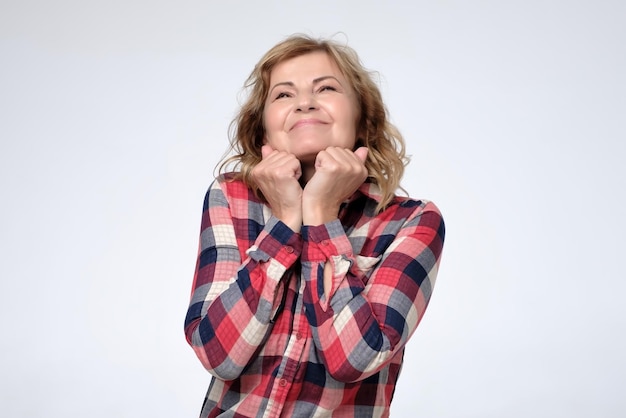 Caucasian mature woman with excitement looking at camera having positive plans on future