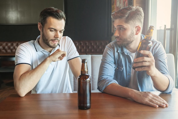 Caucasian men drinking beer in cafe together