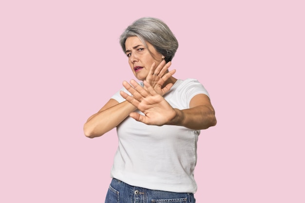 Caucasian midage female on studio background being shocked due to an imminent danger