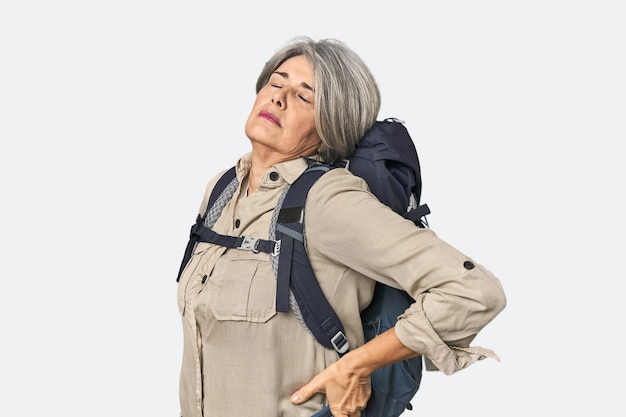 Caucasian midage female with hiking gear suffering a back pain
