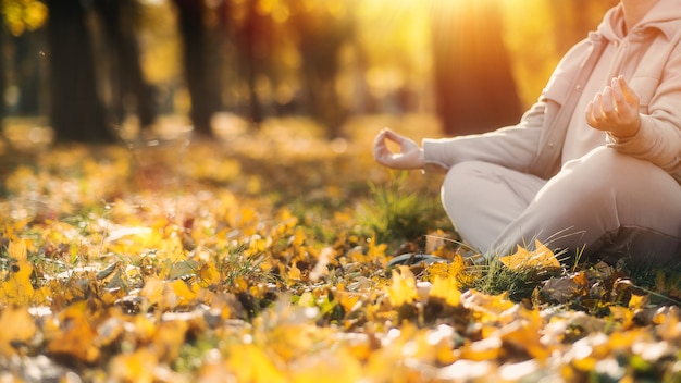 Photo caucasian middle aged woman meditating in lotus pose at autumn park with sunlight. yoga at fall park. woman in glasses relaxing on yellow leaves. meditation, mental health, self care, mindfulness.