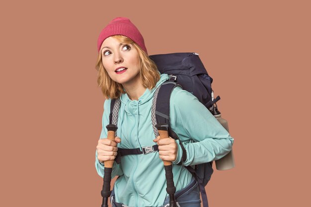 Caucasian middleaged female with hiking backpack in studio