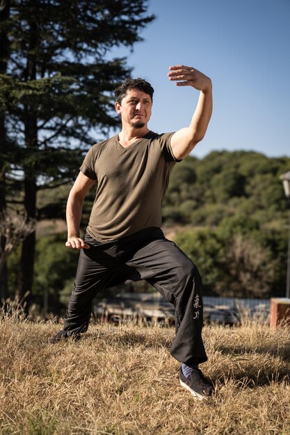Caucasian middleaged man practicing Tai Chi Chuan outdoors