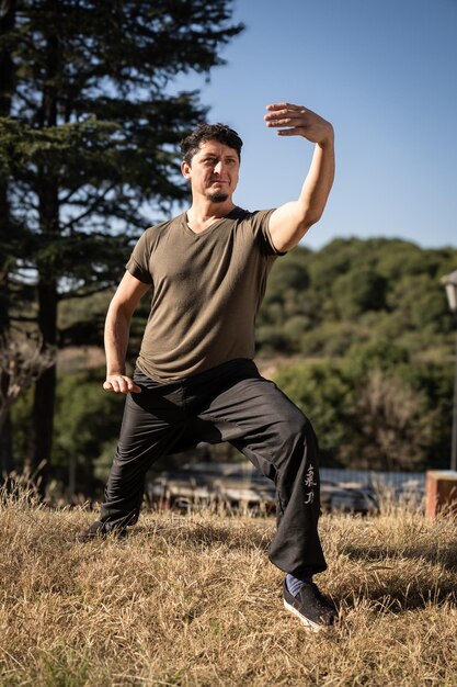 Foto uomo caucasico di mezza età che pratica tai chi chuan all'aperto