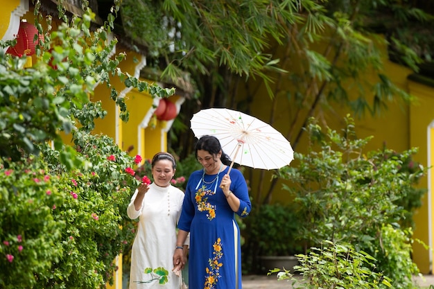 Caucasian mother and Asian Daughter in Ao Dai visit an old town