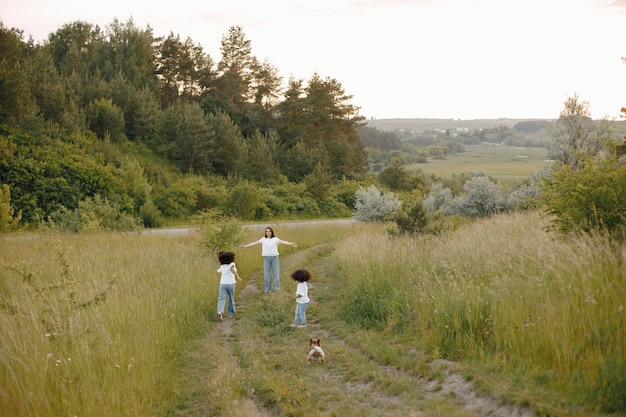 Caucasian mother and two her african american daughters running together