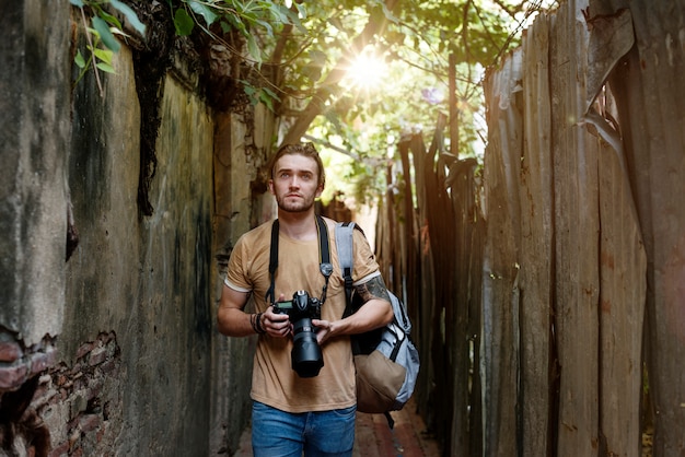 Caucasian photographer is walking in the alley