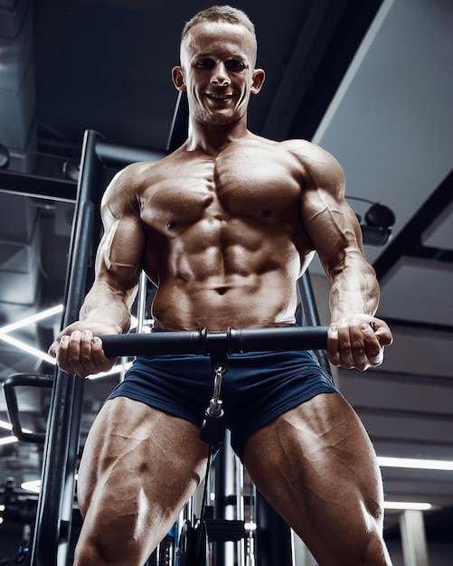 Caucasian power athletic man training pumping up biceps muscles